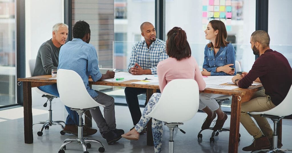 Group of employees talking in boardroom about AI Leadership and Strategy.